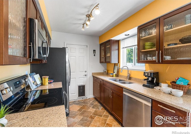 109 Sunflower Dr, Windsor, CO 80550 - kitchen with appliances with stainless steel finishes, glass insert cabinets, dark stone finish flooring, and light stone countertops
