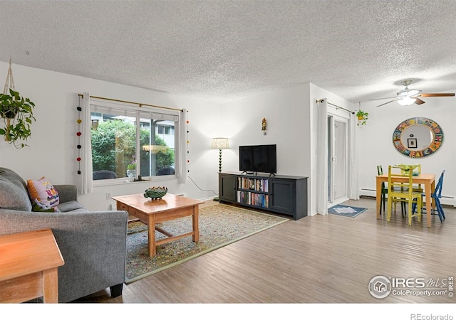 1113 Elysian Field Dr Unit A, Lafayette, CO 80026 - living room with wood finished floors, a textured ceiling, a ceiling fan, and baseboard heating