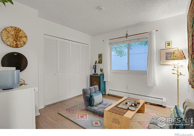 1113 Elysian Field Dr Unit A, Lafayette, CO 80026 - living room with a baseboard heating unit, light wood-style flooring, and a textured ceiling