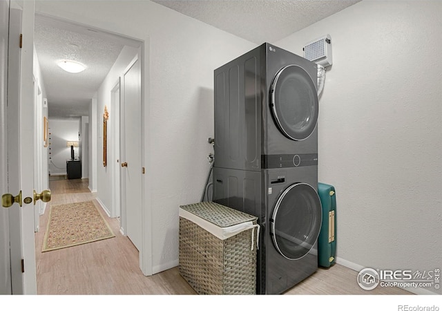 1113 Elysian Field Dr Unit A, Lafayette, CO 80026 - laundry area with stacked washer and clothes dryer, a textured ceiling, and light wood-style floors