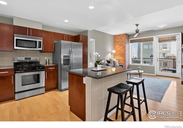 3601 Arapahoe Ave Unit 304, Boulder, CO 80303 - kitchen with stainless steel appliances, light wood finished floors, a breakfast bar area, a ceiling fan, and recessed lighting