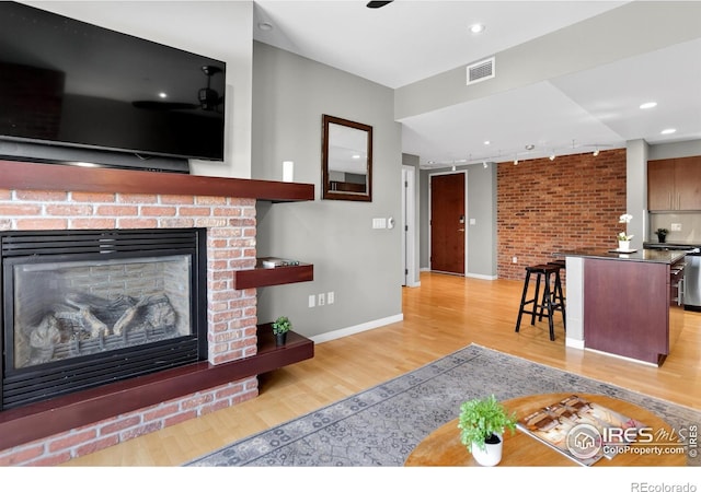 3601 Arapahoe Ave Unit 304, Boulder, CO 80303 - living room featuring light wood-style floors, track lighting, and a fireplace
