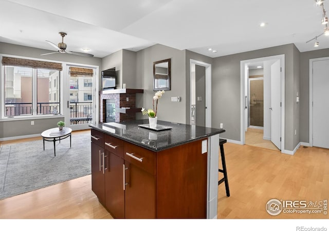 3601 Arapahoe Ave Unit 304, Boulder, CO 80303 - kitchen with light wood finished floors, a center island, a ceiling fan, a fireplace, and recessed lighting