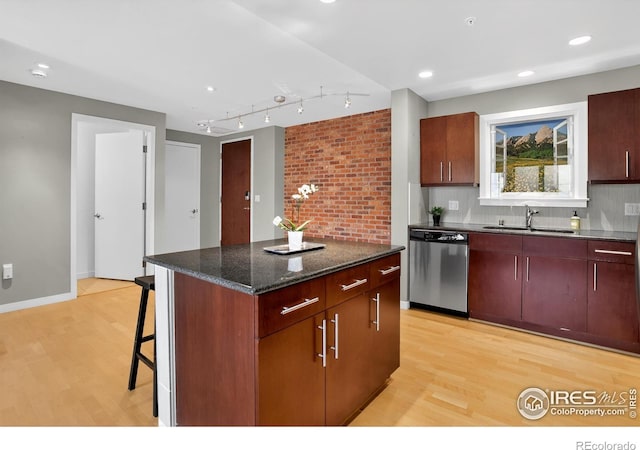 3601 Arapahoe Ave Unit 304, Boulder, CO 80303 - kitchen with dishwasher, light wood-style floors, backsplash, a center island, and a kitchen bar