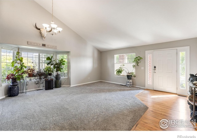 232 Ricker Ln, Johnstown, CO 80534 - foyer with a chandelier, high vaulted ceiling, and wood finished floors