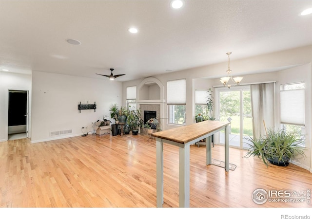 232 Ricker Ln, Johnstown, CO 80534 - kitchen featuring wood finished floors, recessed lighting, a fireplace, ceiling fan, and a chandelier