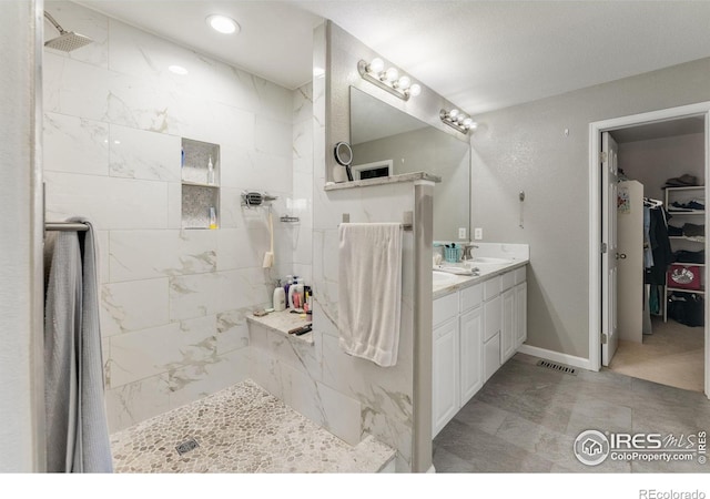 232 Ricker Ln, Johnstown, CO 80534 - full bath featuring double vanity, tiled shower, and a walk in closet