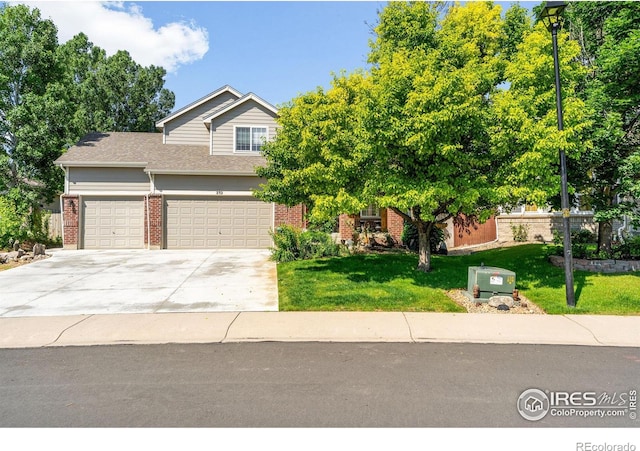 232 Ricker Ln, Johnstown, CO 80534 - view of front of home with brick siding, a front yard, driveway, and an attached garage