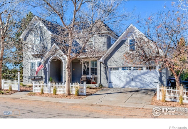 2765 Meadow Mountain Trl, Lafayette, CO 80026 - traditional-style house featuring a fenced front yard, a garage, driveway, and covered porch