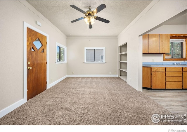 311 12th Ave, Greeley, CO 80631 - kitchen with a textured ceiling, brown cabinets, crown molding, ceiling fan, and built in features