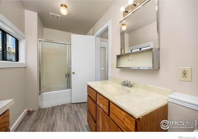 311 12th Ave, Greeley, CO 80631 - bathroom with vanity, wood finished floors, and shower / bath combination with glass door