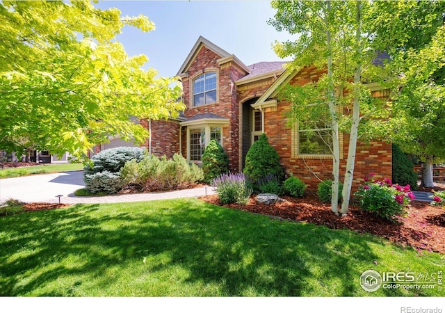 8416 Starfish Ct, Windsor, CO 80528 - view of front of property with a front yard, brick siding, and driveway