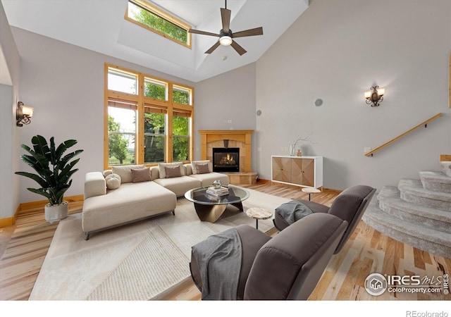 8416 Starfish Ct, Windsor, CO 80528 - living room featuring high vaulted ceiling, a ceiling fan, wood finished floors, a fireplace, and stairs