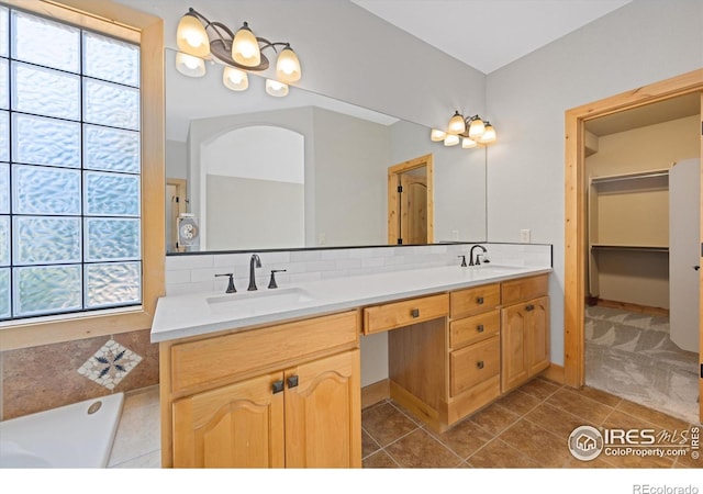 8416 Starfish Ct, Windsor, CO 80528 - full bath with healthy amount of natural light, double vanity, tile patterned floors, and tasteful backsplash