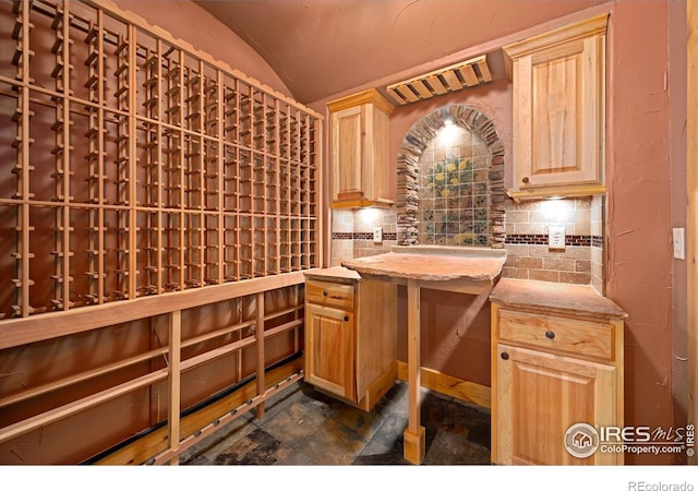 8416 Starfish Ct, Windsor, CO 80528 - wine cellar featuring vaulted ceiling and dark stone finish flooring