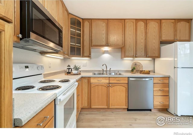 930 Vanderbilt Ct, Fort Collins, CO 80525 - kitchen with appliances with stainless steel finishes, light countertops, glass insert cabinets, and light wood-style flooring