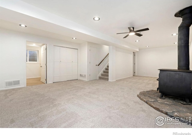 930 Vanderbilt Ct, Fort Collins, CO 80525 - unfurnished living room featuring a wood stove, carpet flooring, recessed lighting, stairway, and ceiling fan