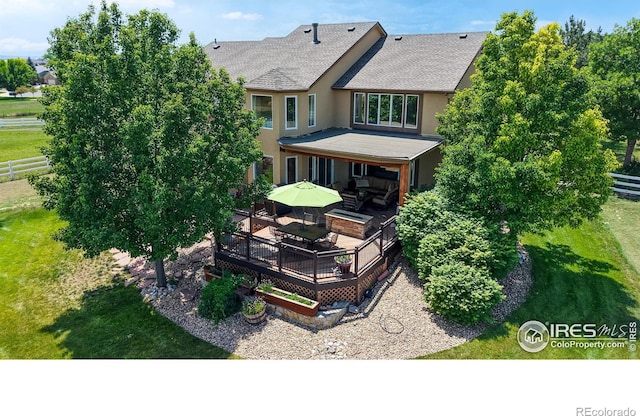 14652 Kalamath Ct, Westminster, CO 80023 - rear view of house featuring a wooden deck, stucco siding, roof with shingles, and outdoor dining area