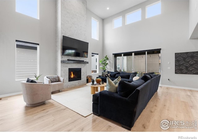 5056 Blanchette St, Timnath, CO 80547 - living room with a towering ceiling, light wood-style floors, and a stone fireplace