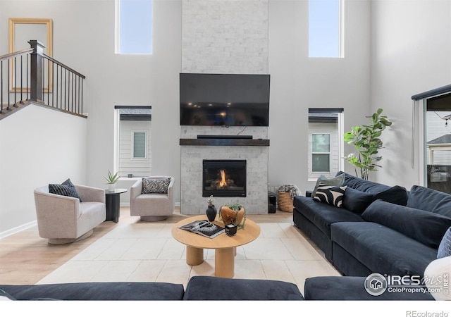 5056 Blanchette St, Timnath, CO 80547 - living area with a high ceiling, a stone fireplace, and stairs