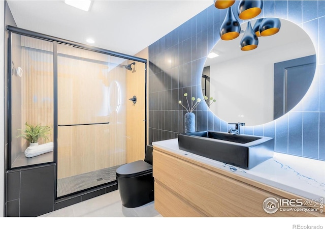 5056 Blanchette St, Timnath, CO 80547 - bathroom with tile walls, a stall shower, vanity, and tile patterned flooring