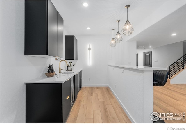 5056 Blanchette St, Timnath, CO 80547 - kitchen with dark cabinets, light countertops, light wood finished floors, pendant lighting, and recessed lighting