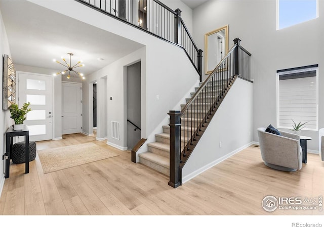5056 Blanchette St, Timnath, CO 80547 - entrance foyer featuring a chandelier, wood finished floors, stairway, and a high ceiling