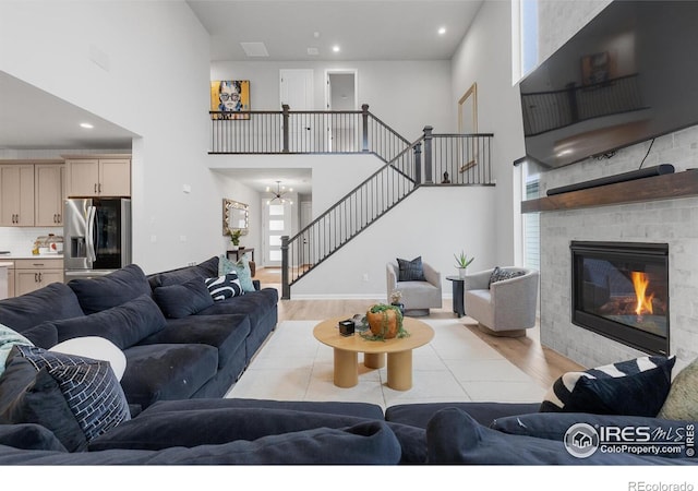 5056 Blanchette St, Timnath, CO 80547 - living area with wood finished floors, stairway, a towering ceiling, a chandelier, and a fireplace