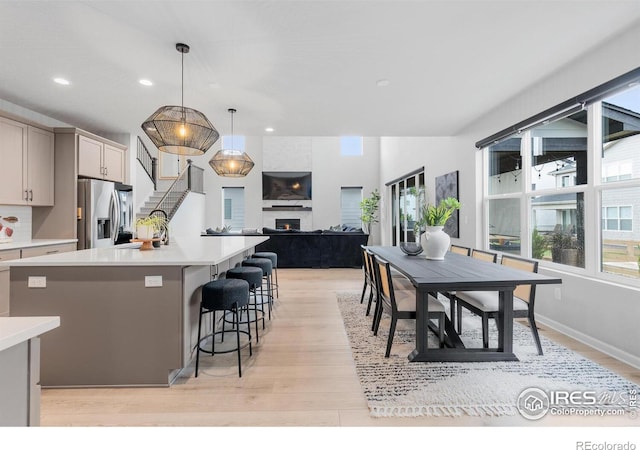 5056 Blanchette St, Timnath, CO 80547 - kitchen with stainless steel refrigerator with ice dispenser, light wood-type flooring, a fireplace, light countertops, and recessed lighting