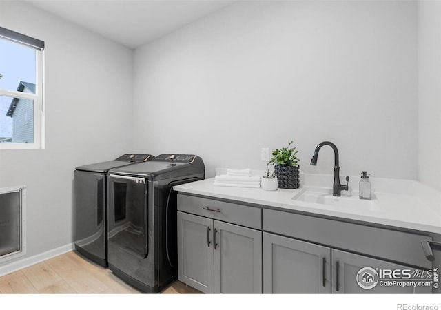 5056 Blanchette St, Timnath, CO 80547 - washroom with independent washer and dryer, cabinet space, and light wood-style flooring