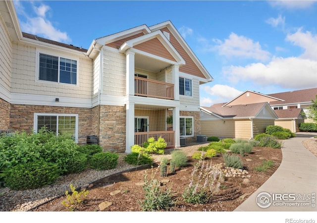 4905 Hahns Peak Dr Unit 202, Loveland, CO 80538 - view of front facade with a balcony and stone siding