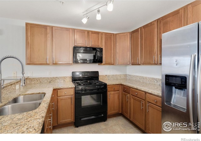 4905 Hahns Peak Dr Unit 202, Loveland, CO 80538 - kitchen featuring black appliances, light stone counters, and brown cabinetry