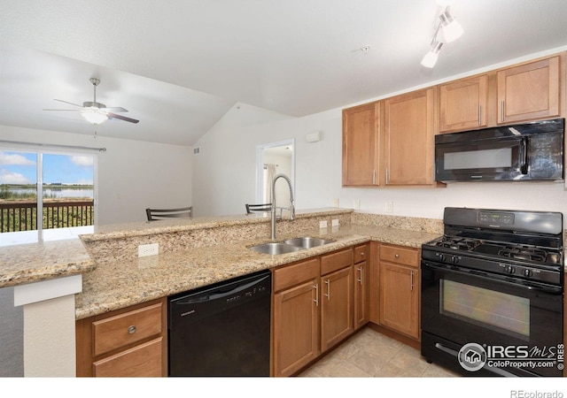 4905 Hahns Peak Dr Unit 202, Loveland, CO 80538 - kitchen with black appliances, light stone countertops, a ceiling fan, lofted ceiling, and a peninsula