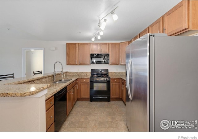4905 Hahns Peak Dr Unit 202, Loveland, CO 80538 - kitchen with black appliances, a peninsula, and light stone counters