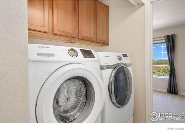 4905 Hahns Peak Dr Unit 202, Loveland, CO 80538 - washroom featuring washing machine and dryer, cabinet space, and carpet flooring