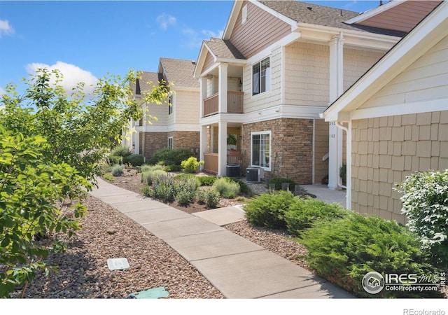 4905 Hahns Peak Dr Unit 202, Loveland, CO 80538 - view of exterior entry with a balcony and stone siding