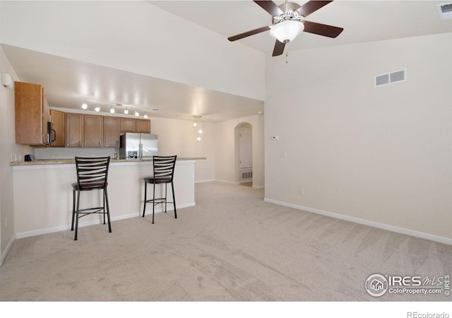 4905 Hahns Peak Dr Unit 202, Loveland, CO 80538 - kitchen with stainless steel fridge with ice dispenser, arched walkways, and light colored carpet