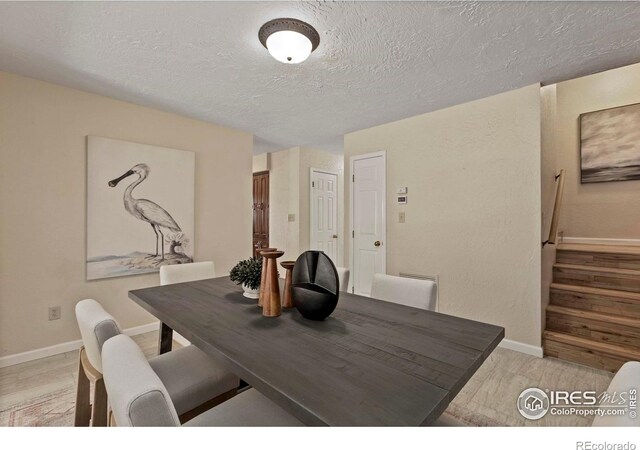 412 Terry Point Dr, Fort Collins, CO 80524 - dining space featuring stairs, a textured ceiling, and light wood-style flooring