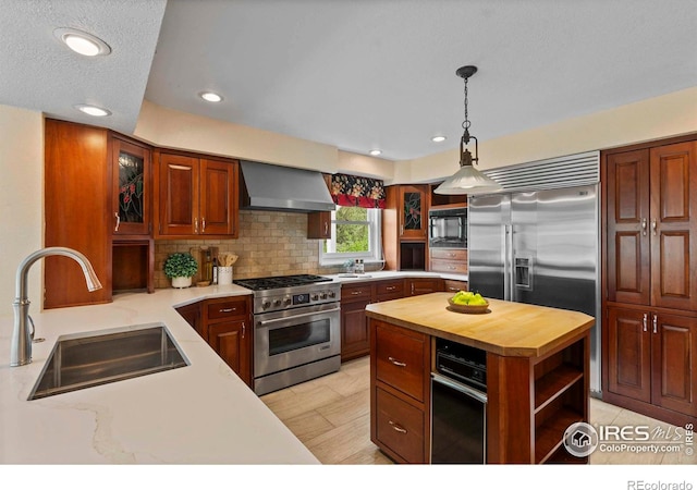412 Terry Point Dr, Fort Collins, CO 80524 - kitchen featuring wall chimney range hood, high end appliances, wood counters, recessed lighting, and decorative backsplash