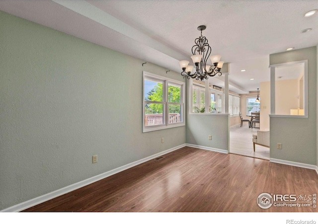 412 Terry Point Dr, Fort Collins, CO 80524 - empty room with wood finished floors, a chandelier, a textured wall, and recessed lighting