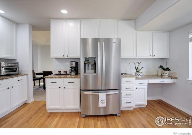 2547 Concord Cir, Lafayette, CO 80026 - kitchen with stainless steel fridge, light wood finished floors, recessed lighting, white cabinets, and light stone counters