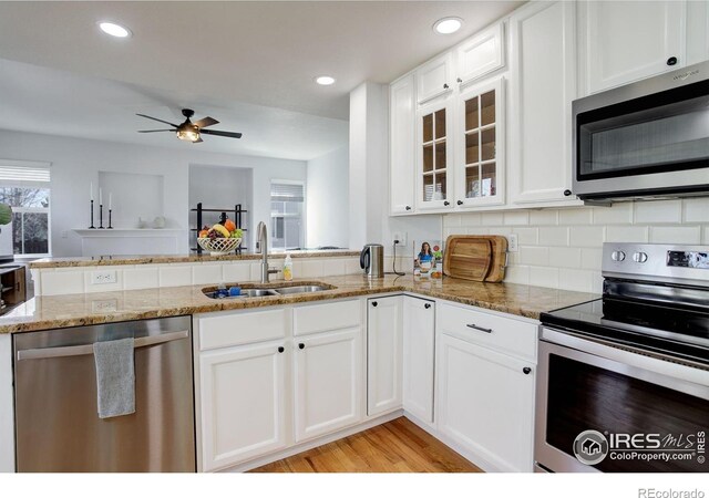 2547 Concord Cir, Lafayette, CO 80026 - kitchen featuring stainless steel appliances, light stone counters, white cabinetry, ceiling fan, and glass insert cabinets