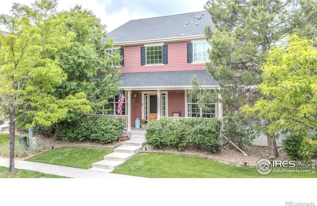 8367 Devinney St, Arvada, CO 80005 - view of front of home featuring covered porch, roof with shingles, and a front lawn