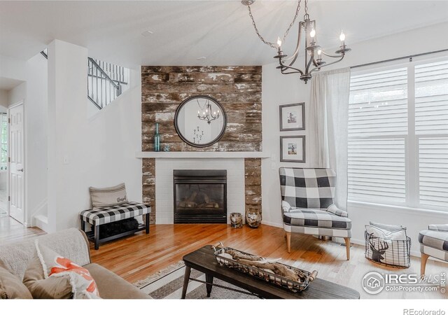8367 Devinney St, Arvada, CO 80005 - living room with a chandelier, wood finished floors, plenty of natural light, and a fireplace