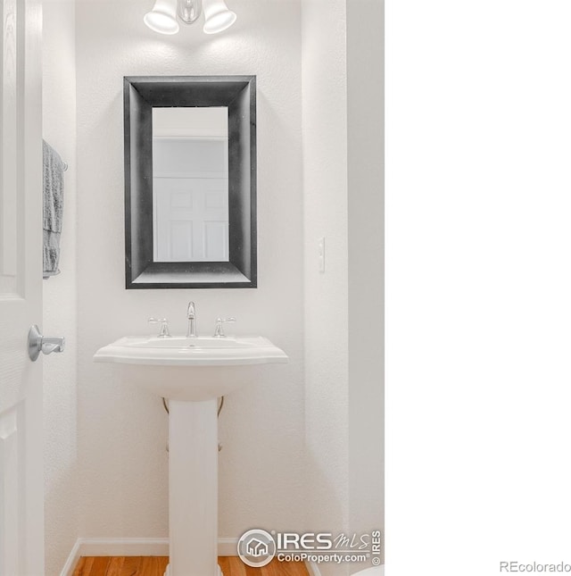 8367 Devinney St, Arvada, CO 80005 - bathroom featuring wood finished floors and baseboards