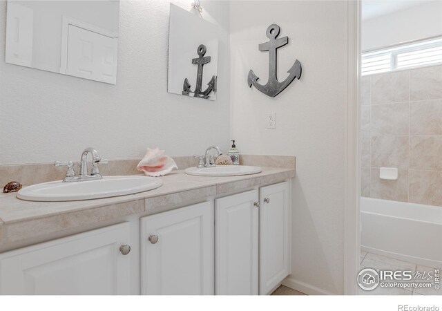 8367 Devinney St, Arvada, CO 80005 - full bath with double vanity and shower / washtub combination