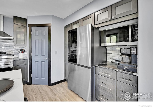 1424 Sheep Ridge Rd, Fairplay, CO 80440 - kitchen featuring stainless steel appliances, wall chimney range hood, tasteful backsplash, and light wood-style floors