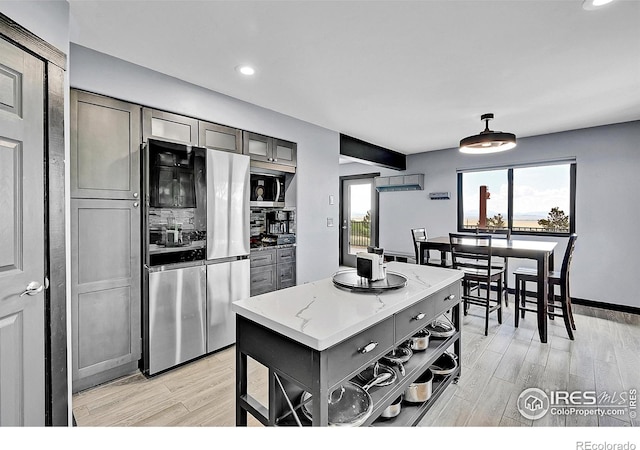 1424 Sheep Ridge Rd, Fairplay, CO 80440 - kitchen with appliances with stainless steel finishes, gray cabinets, open shelves, light wood-style floors, and light stone countertops
