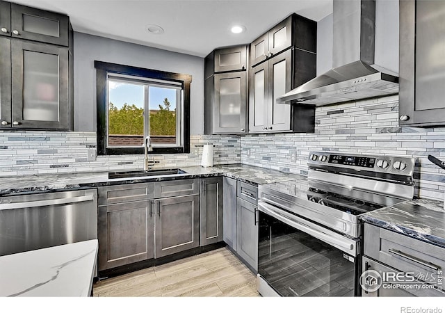 1424 Sheep Ridge Rd, Fairplay, CO 80440 - kitchen with stainless steel appliances, wall chimney exhaust hood, dark stone counters, backsplash, and light wood-type flooring
