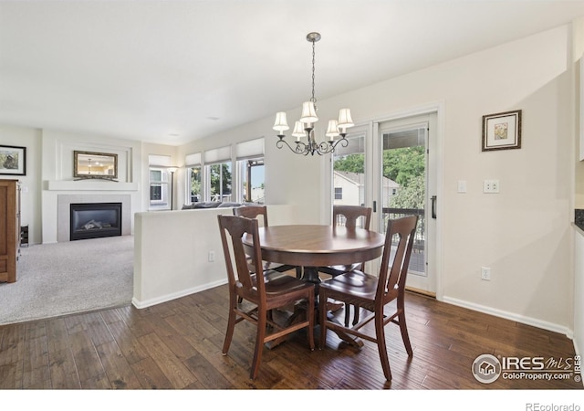 2608 E 132nd Ave, Thornton, CO 80241 - dining space with a glass covered fireplace, dark wood-style floors, and a chandelier